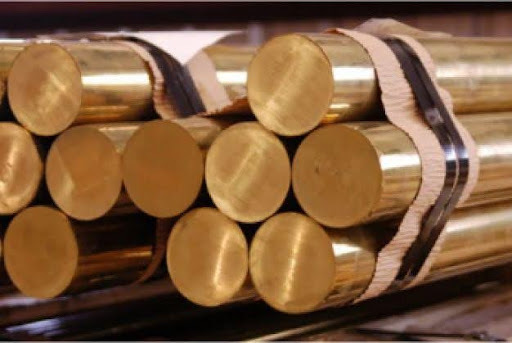 Close-up of bundled solid brass round bars stacked together.