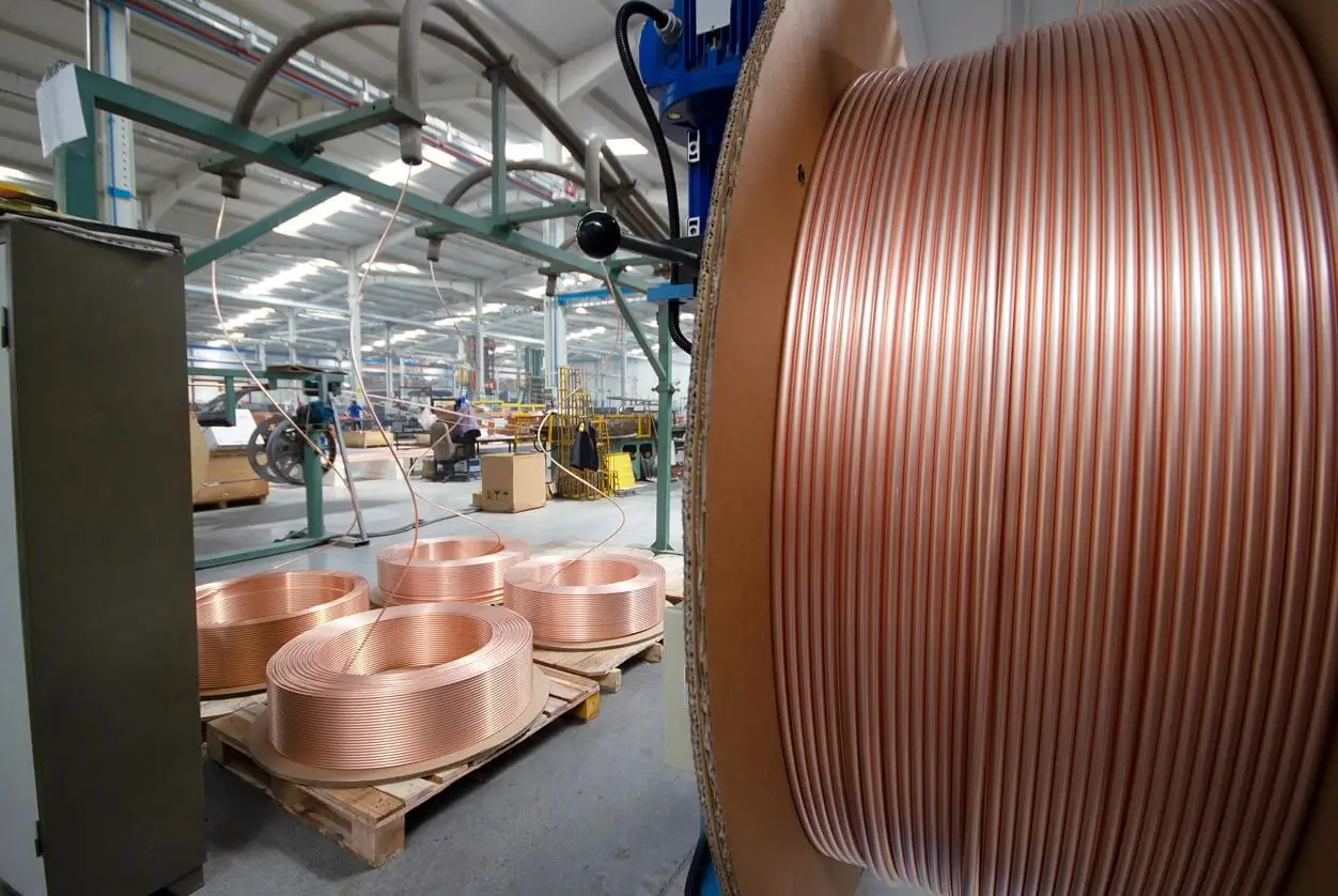 Coils of copper tubing on pallets in a manufacturing facility.